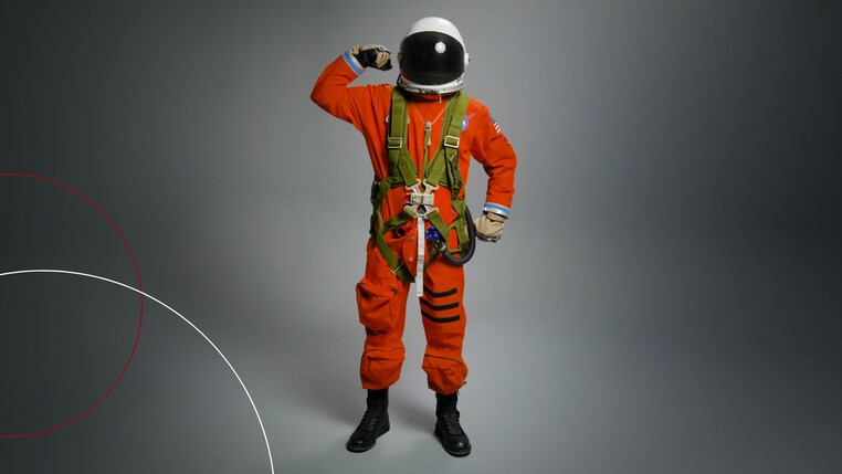 Astronaut mit Helm hebt einen Arm
