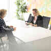 Zwei Frauen sitzen an einem Meetingtisch