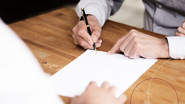 Eine Person unterzeichnet ein Dokument