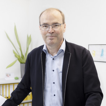 Frank Hansen steht an seinem Schreibtisch