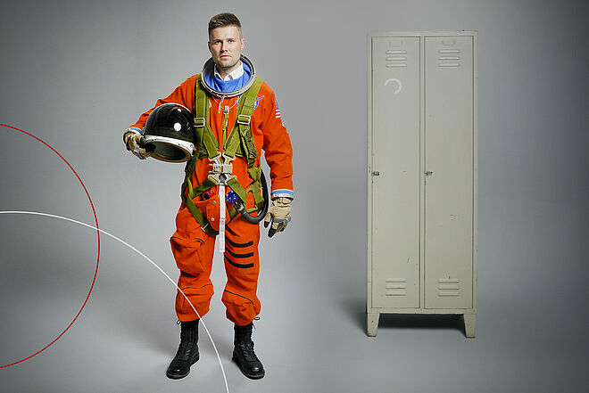 Finn Horn im Astronautenanzug vor einem Spind